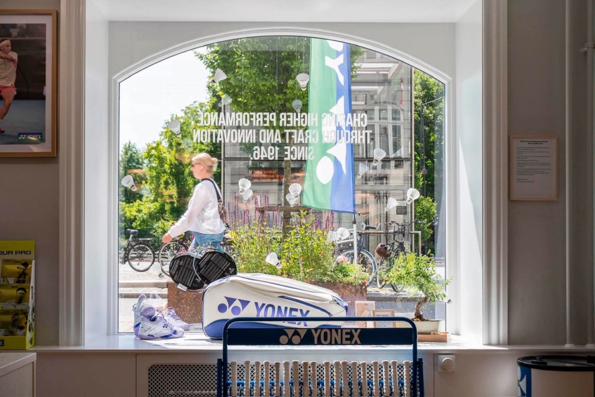Inde i Yonex Store Copenhagen — Yonex bag ved bonsai og arched window