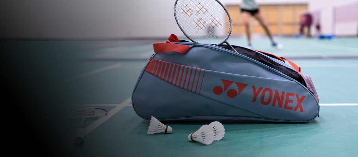 Yonex pro-bag, ketcher og fjerbolde på badmintonbane
