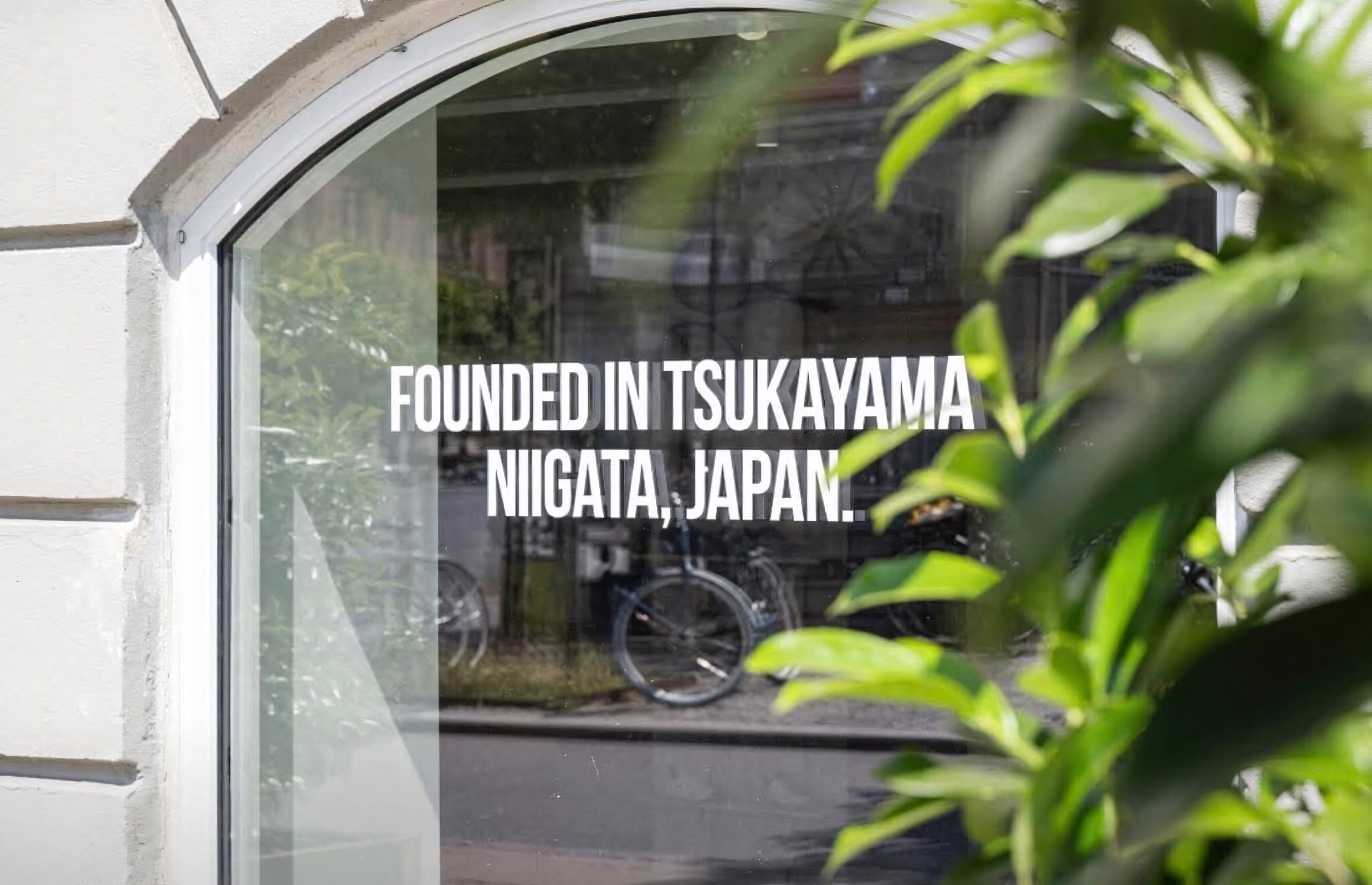 Yonex Store Copenhagen — 'Founded in Tsukayama Niigata, Japan' frosted window text